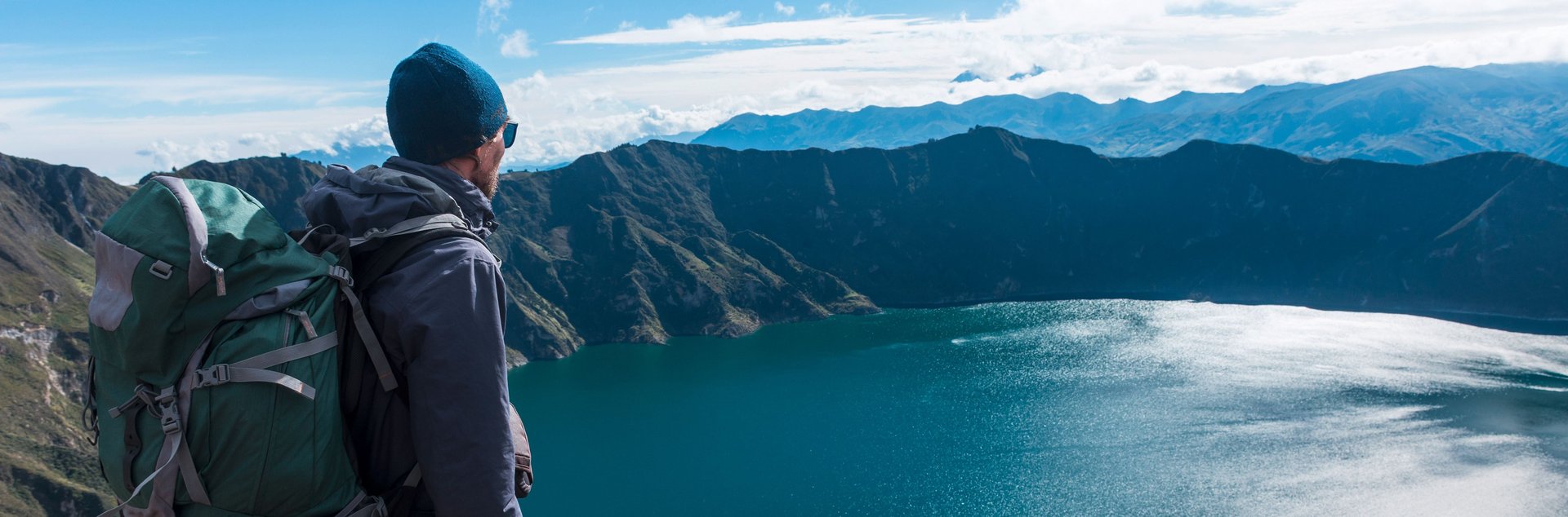 Sustainable hiking tourism A man looks down on a mountain lake from above