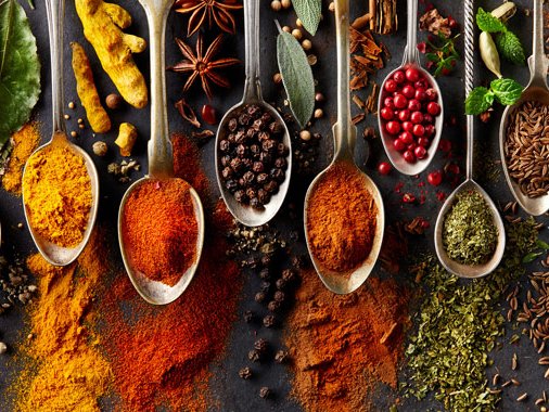 A selection of different spices is presented on spoons