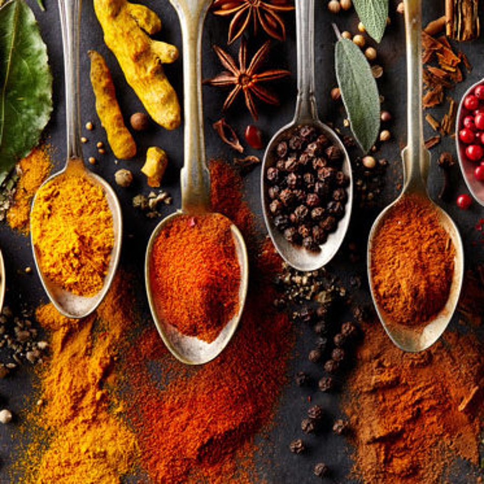 A selection of different spices is presented on spoons