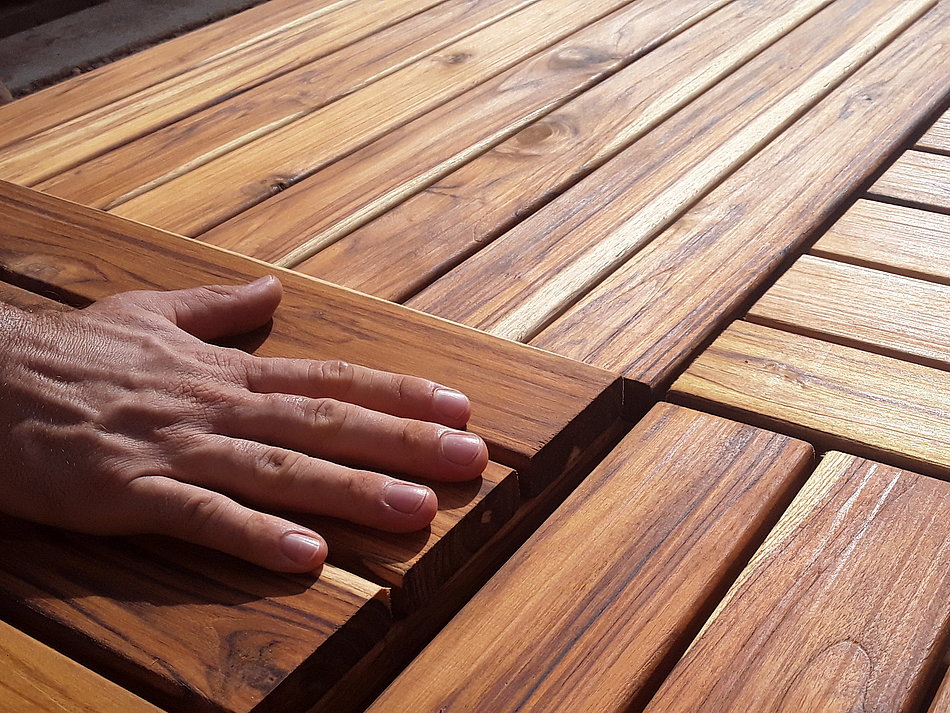 A hand is feeling wooden boards