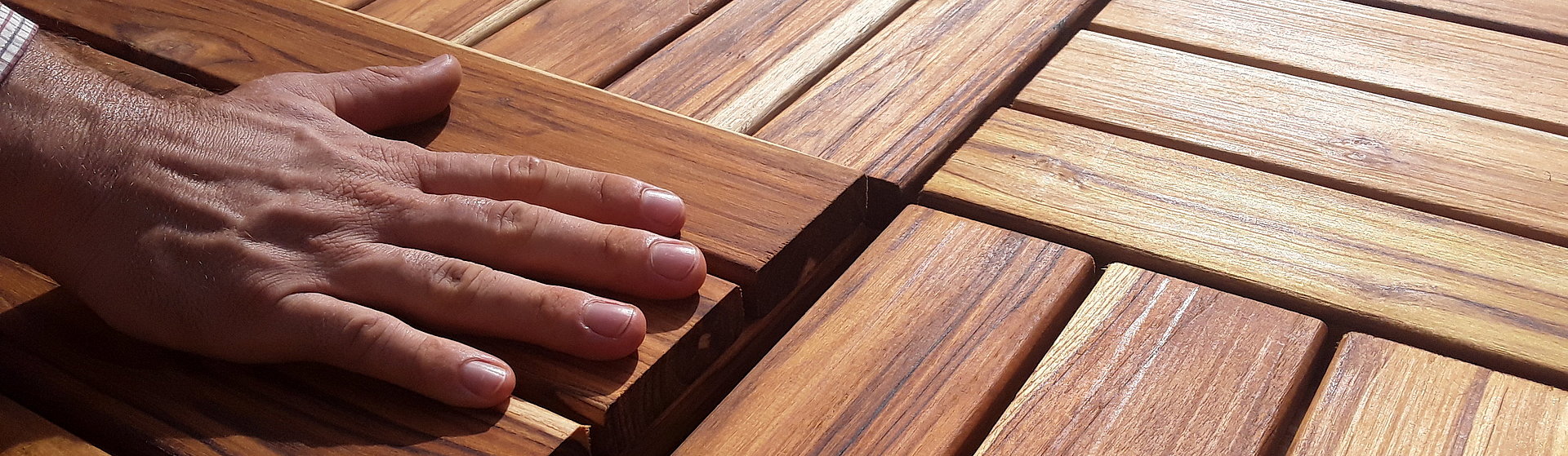 Eine Hand streicht über Holzplatten