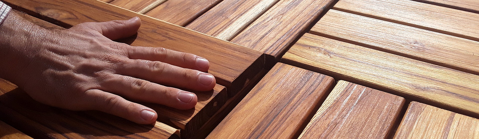 Nachhaltige Holzprodukte der IPD-Exporteure Eine Hand streicht über Holzplatten
