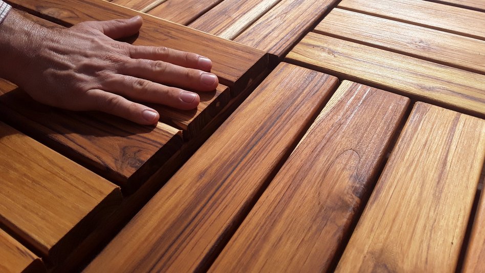 A hand is feeling wooden boards