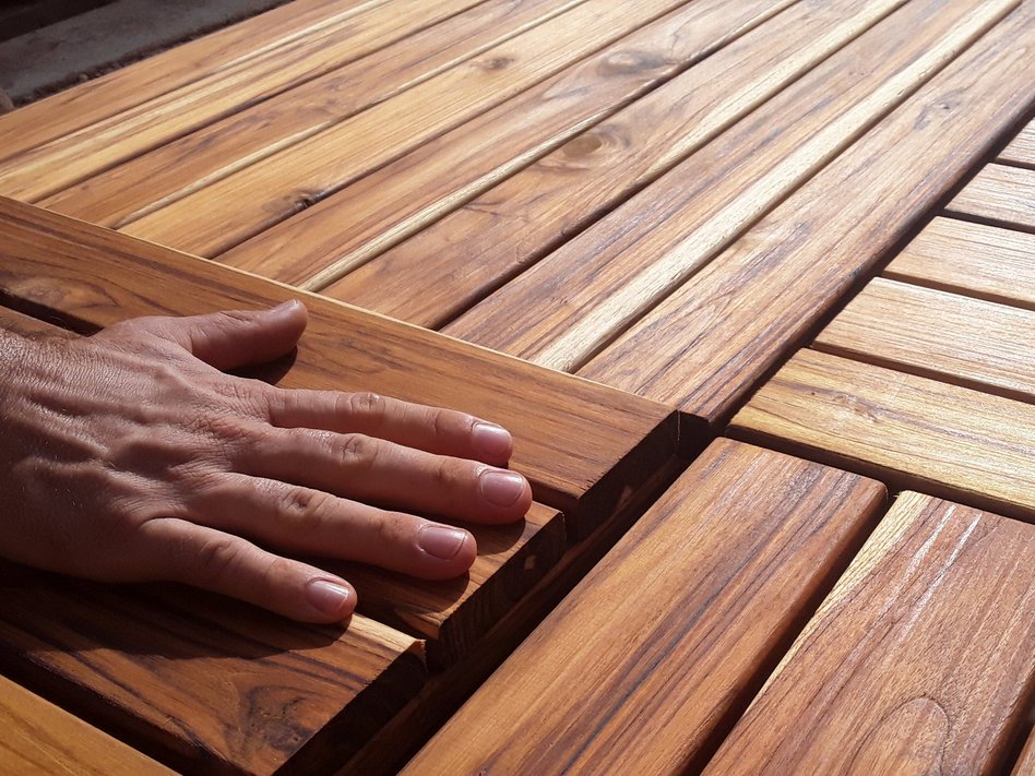A hand is feeling wooden boards